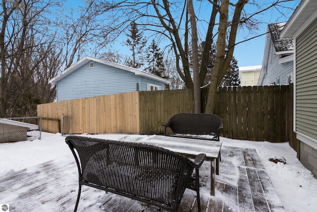 snow covered patio with a deck