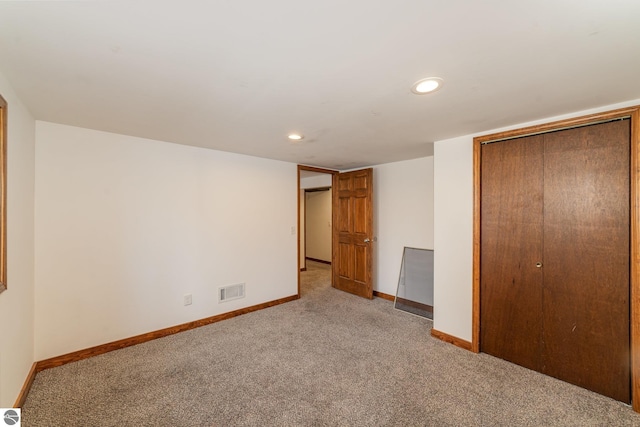 unfurnished bedroom with light carpet and a closet