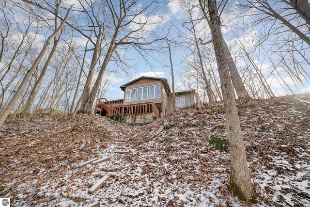 snow covered house featuring a wooden deck