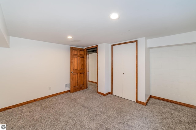 unfurnished bedroom with light colored carpet and a closet