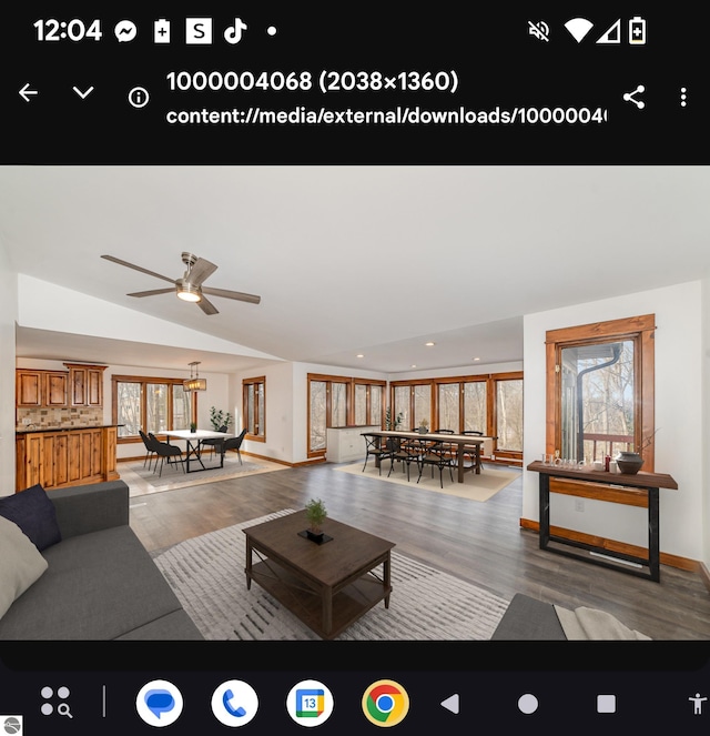 living room with ceiling fan, lofted ceiling, and hardwood / wood-style floors