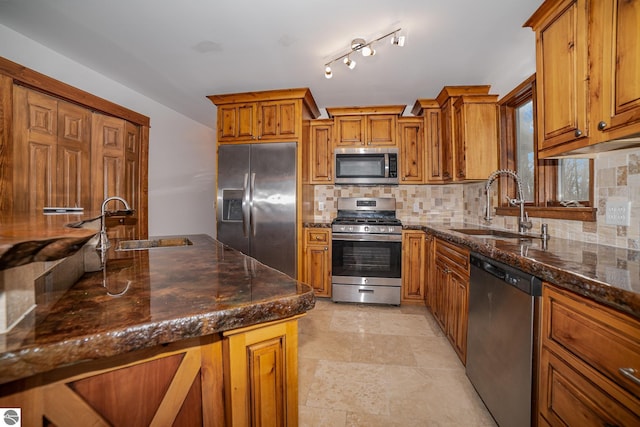 kitchen with stainless steel appliances, decorative backsplash, dark stone counters, and sink