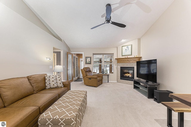 living room featuring carpet flooring, ceiling fan, a tile fireplace, and vaulted ceiling