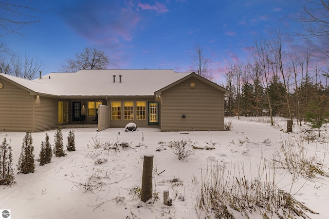 view of snow covered back of property