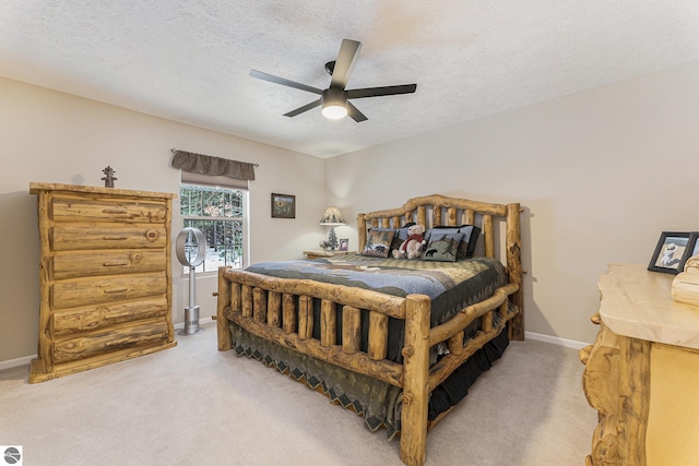 carpeted bedroom featuring a textured ceiling and ceiling fan