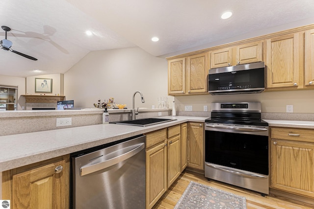 kitchen featuring ceiling fan, sink, light hardwood / wood-style floors, vaulted ceiling, and appliances with stainless steel finishes