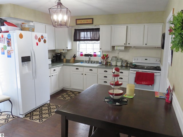 kitchen with white cabinetry, sink, an inviting chandelier, decorative light fixtures, and white appliances