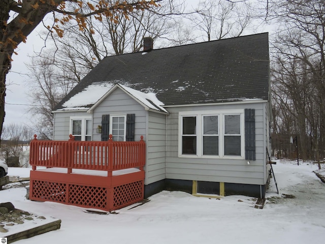 snow covered rear of property with a wooden deck