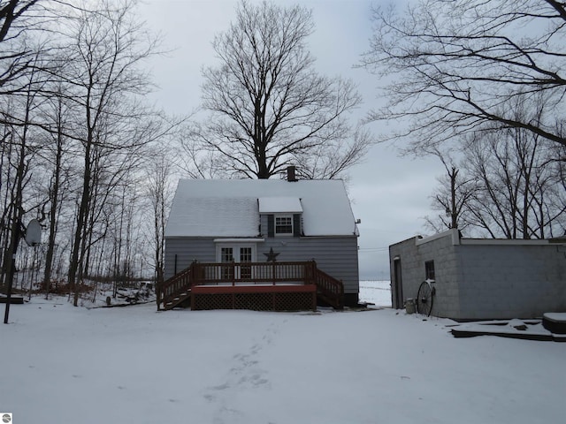 snow covered rear of property featuring a wooden deck