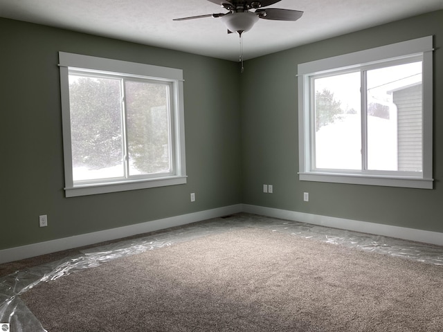 carpeted spare room featuring ceiling fan