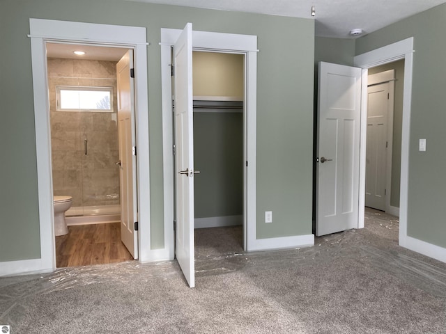 unfurnished bedroom featuring carpet flooring, ensuite bathroom, and a closet