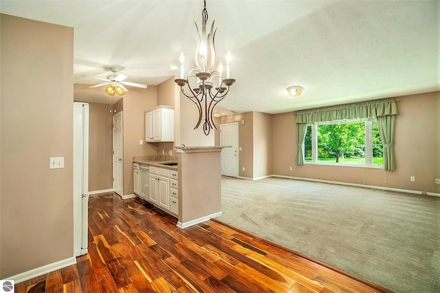 kitchen with pendant lighting, white cabinets, ceiling fan with notable chandelier, dark hardwood / wood-style floors, and light stone counters