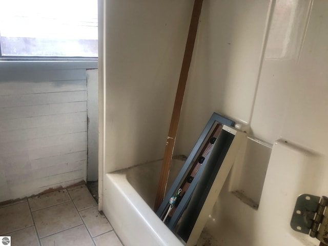 bathroom with tile patterned flooring and a tub to relax in