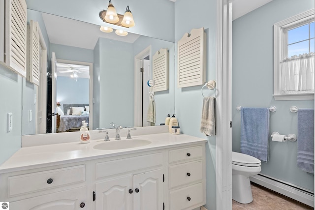 bathroom with vanity, ceiling fan, toilet, and a baseboard heating unit