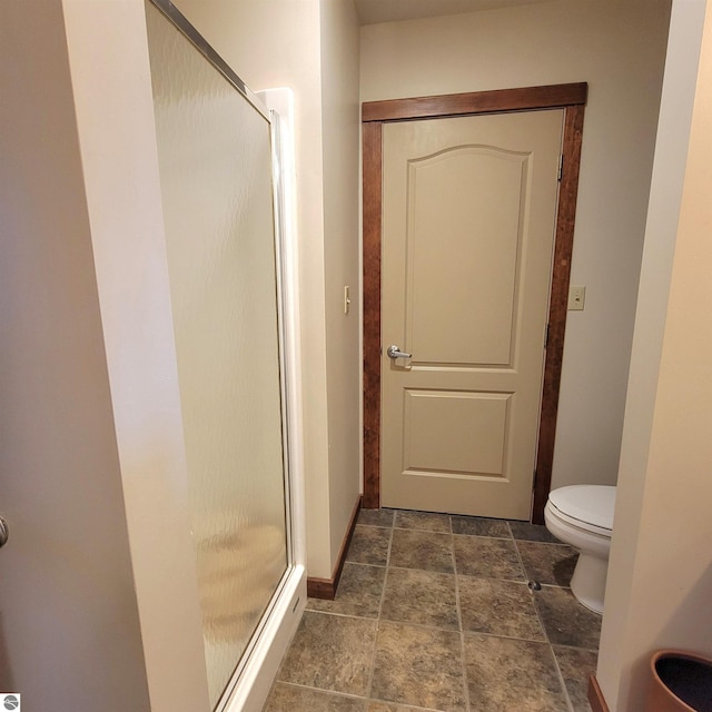 bathroom with toilet and a shower with door