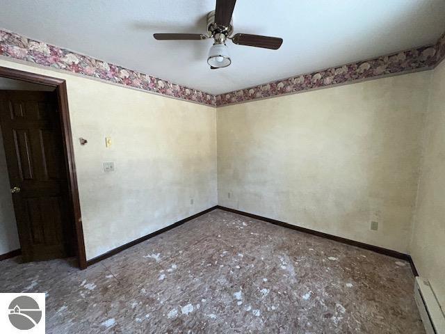 unfurnished room featuring a baseboard radiator and ceiling fan