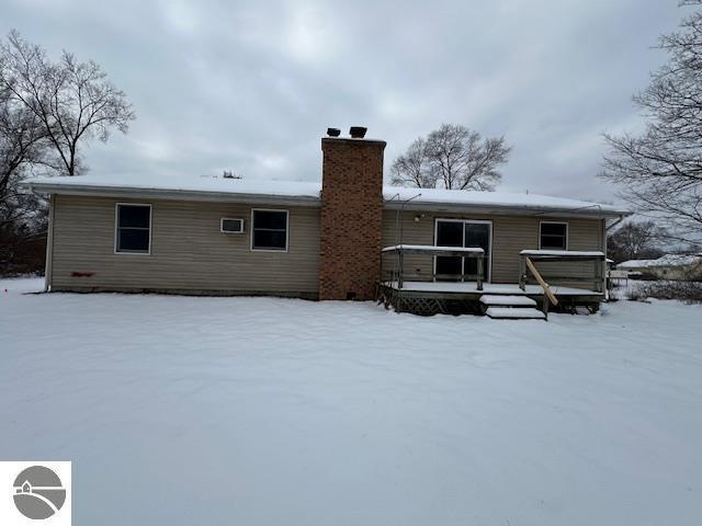 snow covered property with a deck