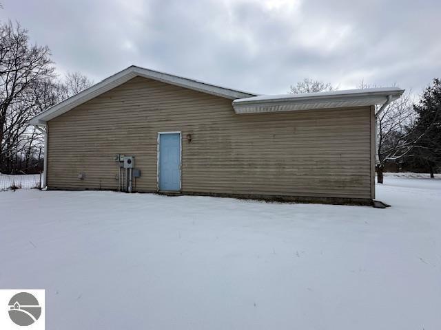 view of snow covered back of property