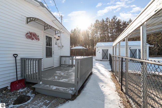 snow covered deck featuring a shed