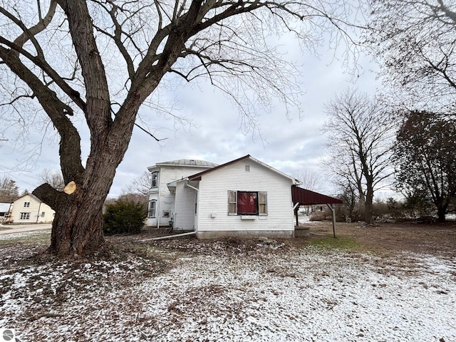 snow covered property with a carport