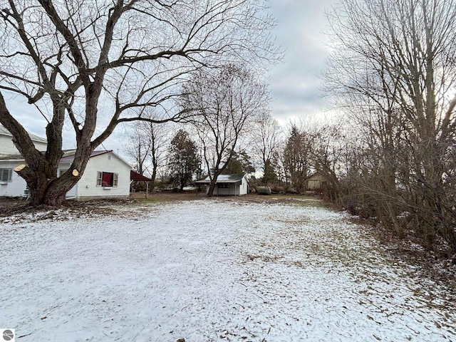 yard covered in snow with a storage unit