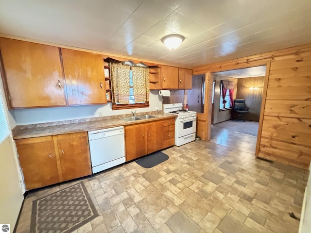 kitchen featuring sink, white appliances, and wood walls