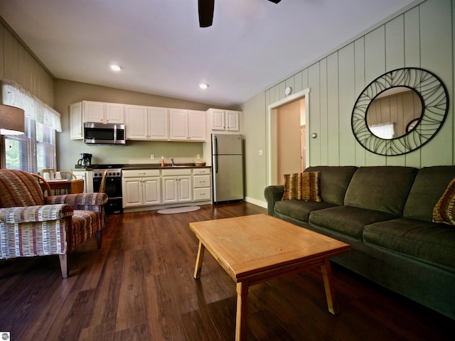 living room featuring ceiling fan, lofted ceiling, and dark wood-type flooring