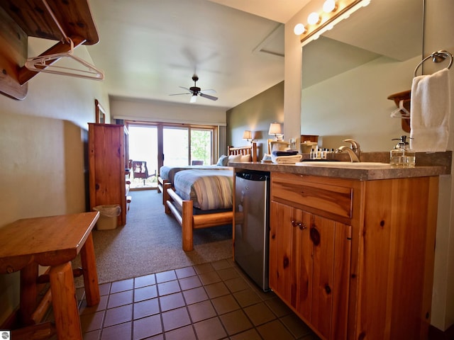 bedroom with refrigerator, dark tile patterned floors, and sink