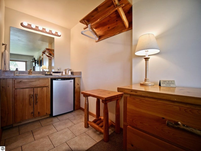 kitchen with light tile patterned floors and fridge