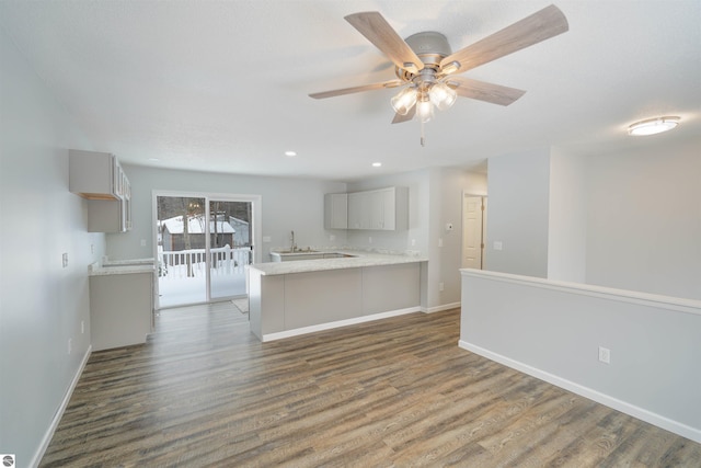 kitchen featuring kitchen peninsula, ceiling fan, dark hardwood / wood-style flooring, and gray cabinets