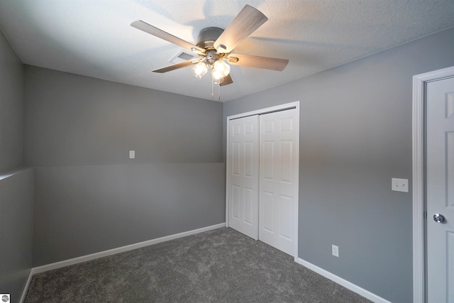 unfurnished bedroom featuring ceiling fan, a closet, and dark carpet