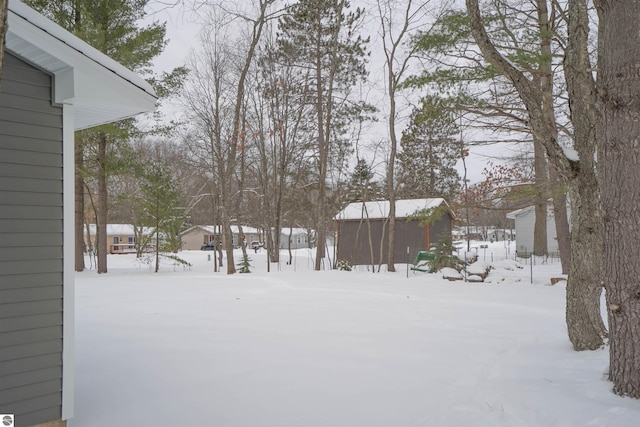 yard layered in snow featuring an outdoor structure