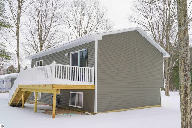 snow covered property with a wooden deck