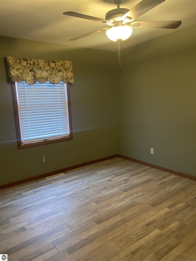 empty room with hardwood / wood-style floors and ceiling fan