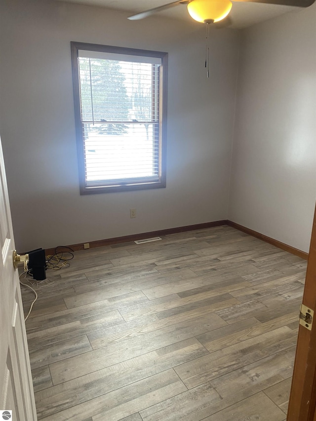 spare room with ceiling fan and wood-type flooring