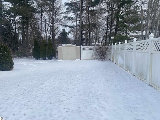 snowy yard featuring a shed