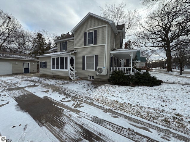 front facade featuring ac unit, a garage, and an outdoor structure