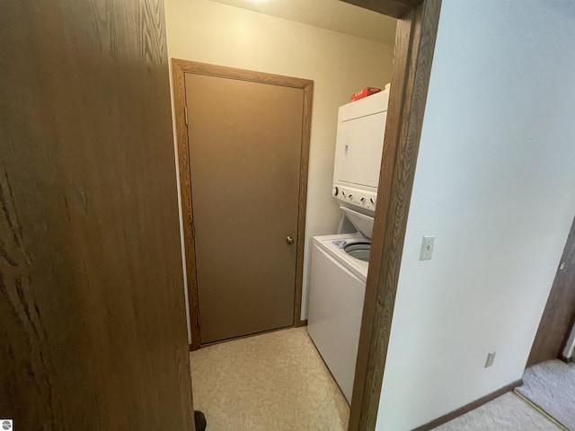 clothes washing area with stacked washer / dryer