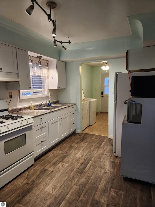 kitchen featuring dark hardwood / wood-style flooring, white cabinets, sink, washing machine and clothes dryer, and white range with gas stovetop