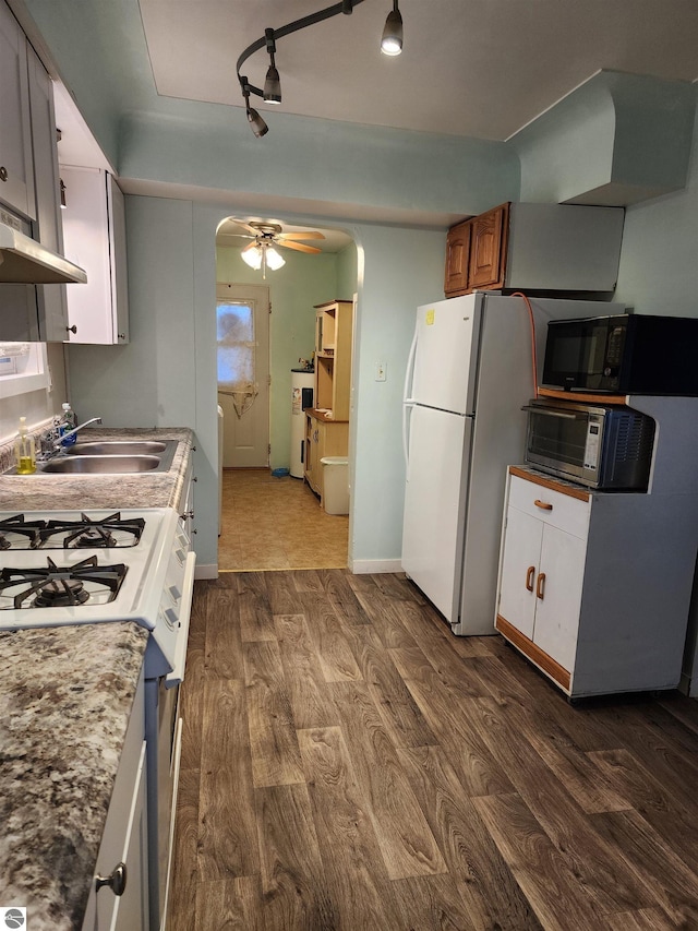 kitchen with white appliances, ceiling fan, sink, white cabinets, and dark hardwood / wood-style floors