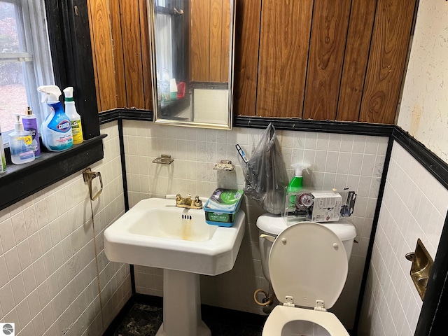 bathroom featuring toilet and tile walls