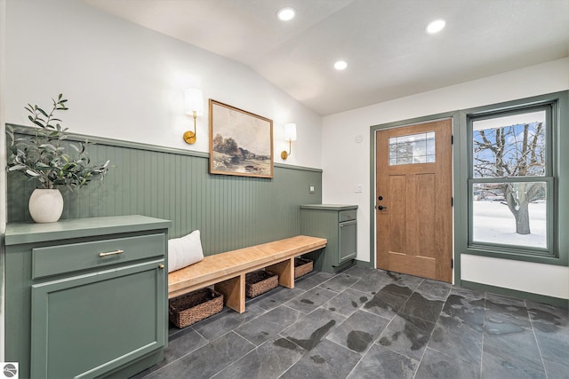 entryway featuring lofted ceiling and wood walls