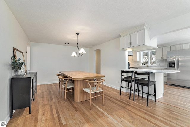 dining space with a notable chandelier and light wood-type flooring