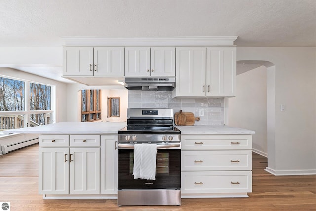 kitchen with stainless steel range, a baseboard heating unit, white cabinets, and tasteful backsplash