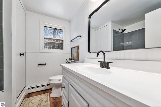 bathroom featuring toilet, a shower, hardwood / wood-style flooring, a baseboard radiator, and vanity