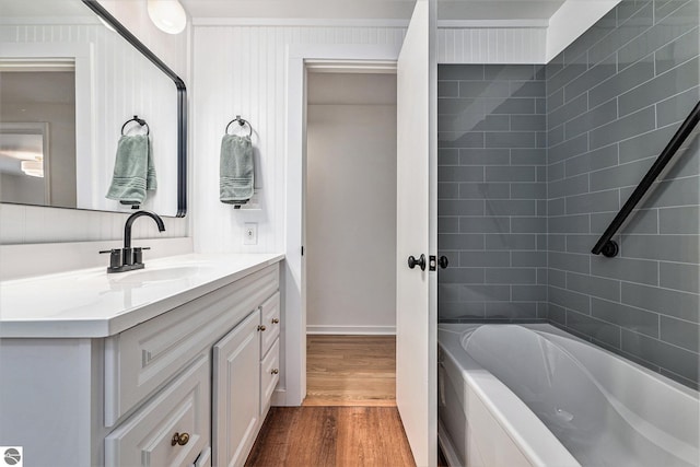 bathroom featuring vanity, tiled shower / bath combo, and hardwood / wood-style flooring