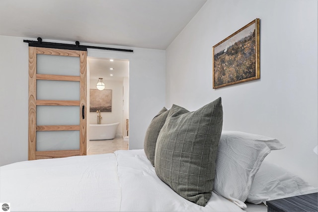 bedroom featuring connected bathroom and a barn door