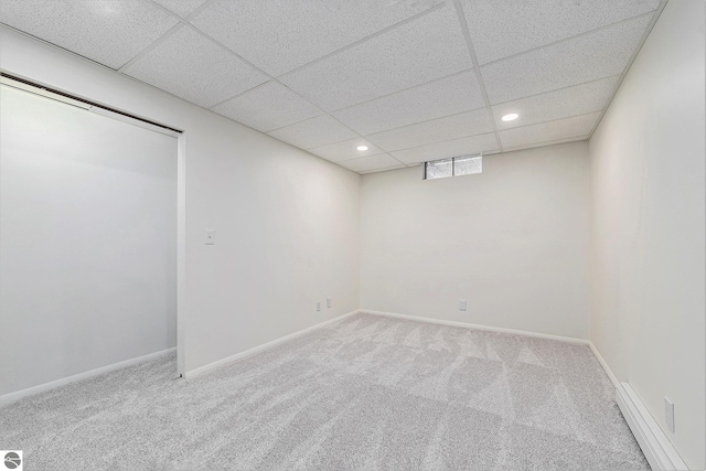 basement featuring a drop ceiling and carpet