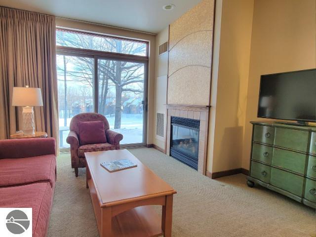 living room featuring light carpet and a fireplace