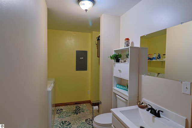 bathroom with electric panel, toilet, washer / clothes dryer, and sink